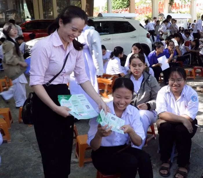 Cán bộ ngân hàng trực tiếp hướng dẫn và phát tờ rơi tuyên truyền về chương trình vay vốn ưu đãi cho học sinh theo đuổi khối ngành STEM.