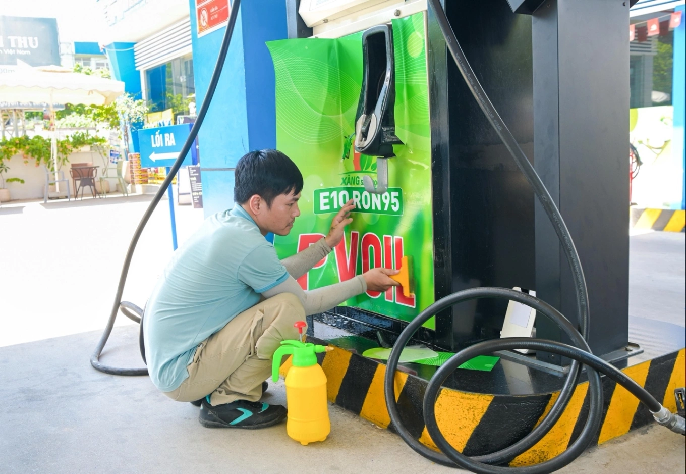 Đơn vị thi công dán nhãn xăng E10 tại trụ bơm. Ảnh: PVOIL