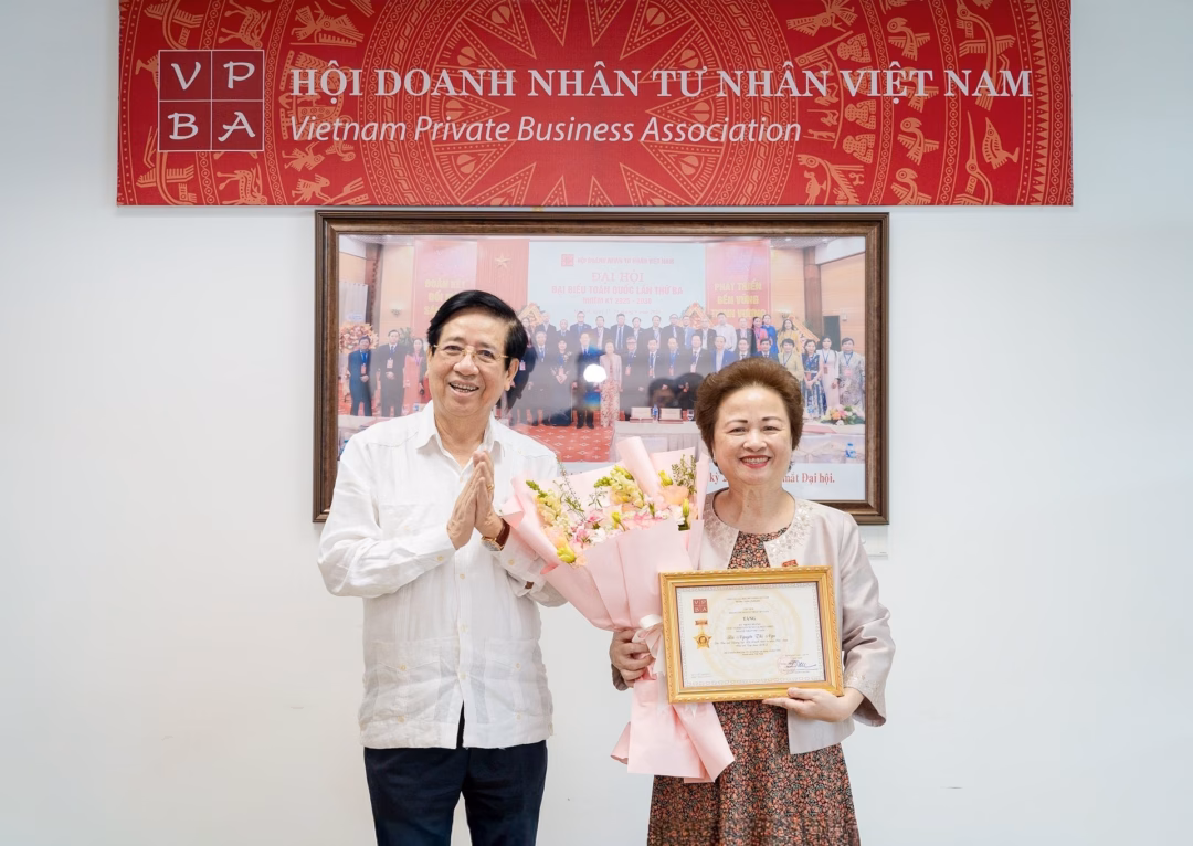 PGS.TS Nguyễn Trọng Điều, Chủ tịch Hội Doanh nhân Tư nhân Việt Nam, trao kỷ niệm chương cho bà Nguyễn Thị Nga